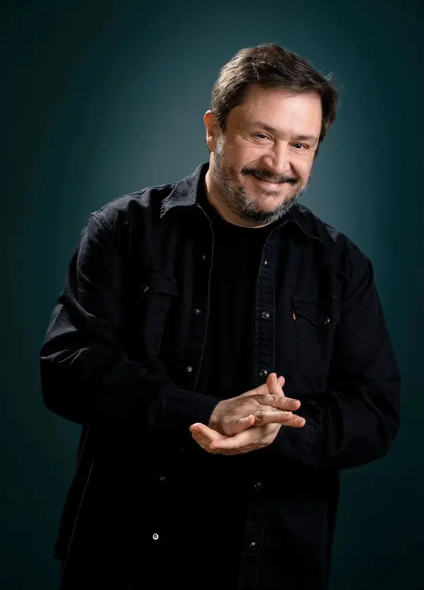 Hernán Casciari, de pie, sonríe con las manos juntas.