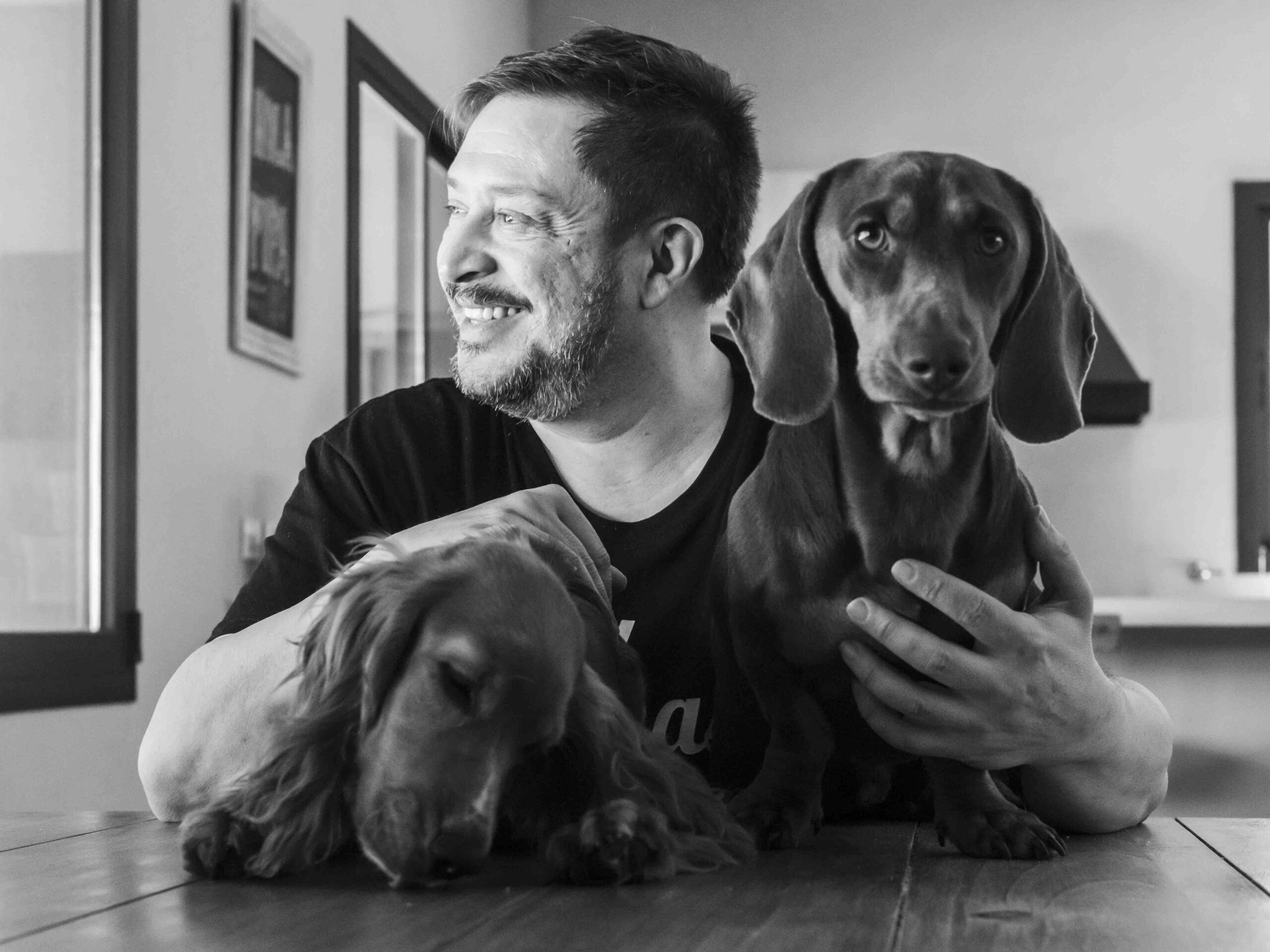 Hernán Casciari sonriendo junto a sus dos perros